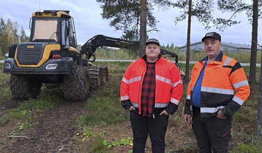 Jere och Jorma Hirsimäki står framför en skogsmaskin, vända mot kameran.