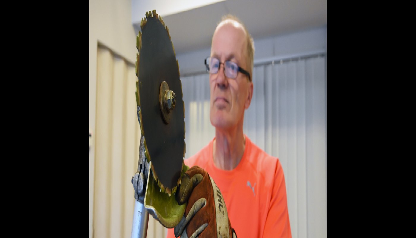 Jarmo Lepola tittar på sin röjsåg.