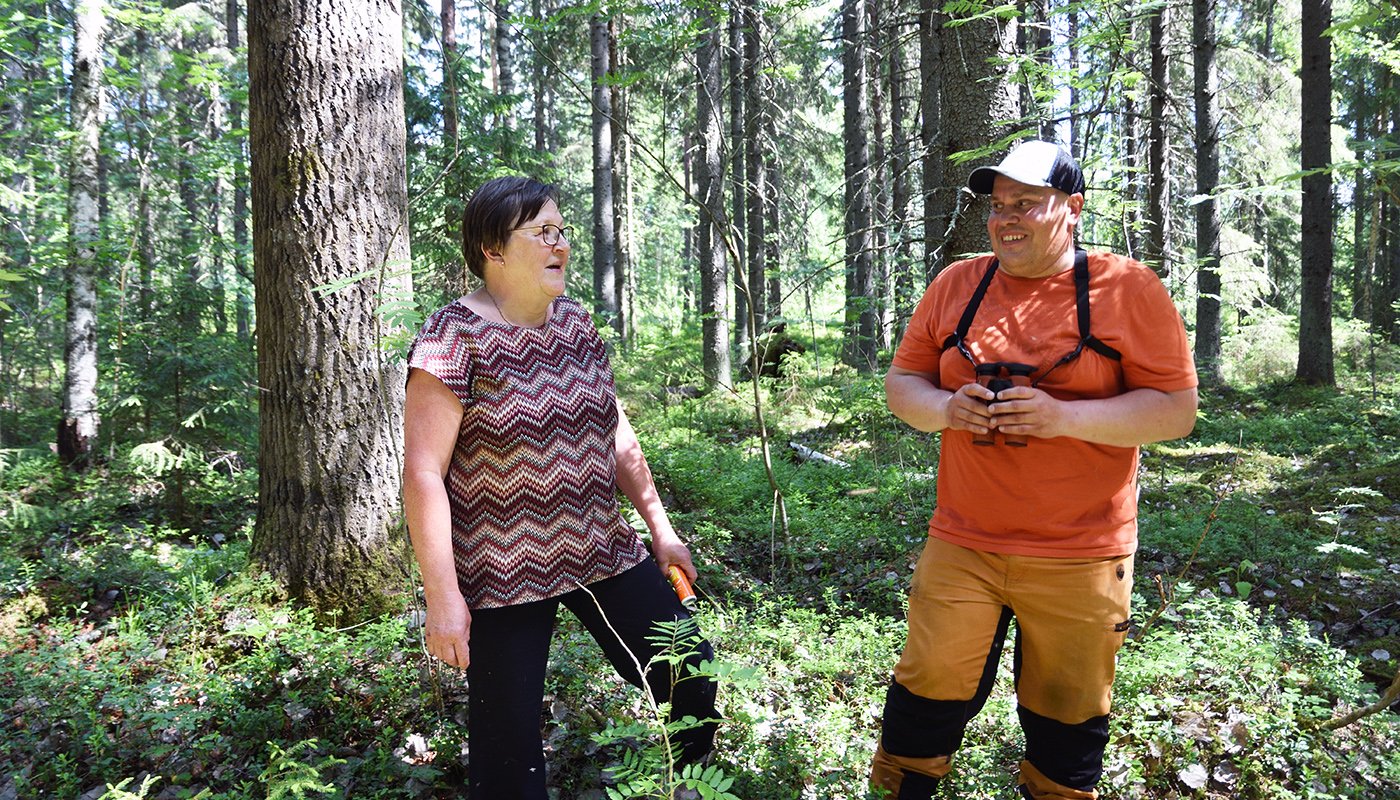 Raija Hämäläinen och Teemu Ukkonen i skogen.