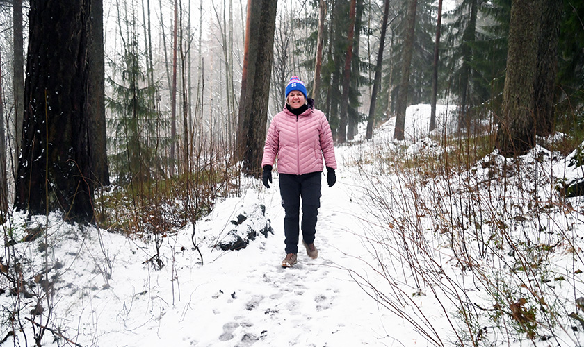 Heli Lehtomäki går längs en skogsstig. 