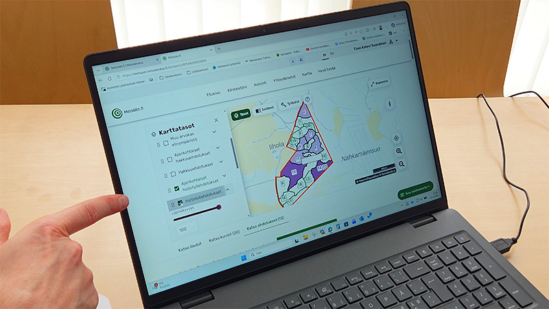  På den bärbara datorns skärm finns tjänsten MinSkog.fi öppen med förslag på skogsvårdsåtgärder. 