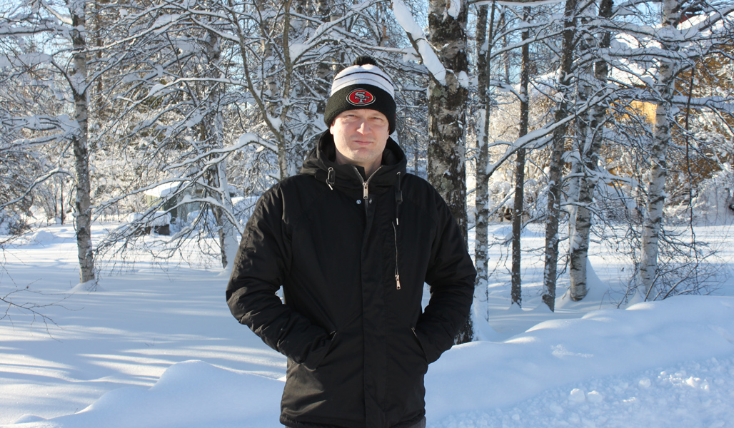 Sami Paasonen fotograferad framför snötyngda björkar.