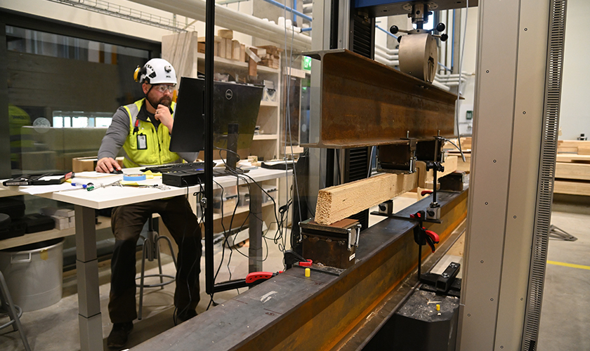 Pasi Eskelinen följer med träböjningstestet i laboratoriet. 