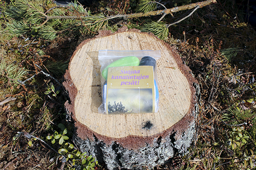 Ett skyddspaket för hönsfåglars bon i en plastförpackning fotograferad på en stubbe.