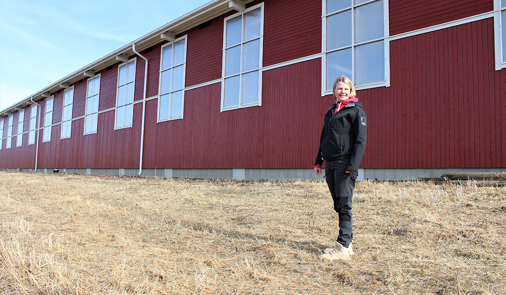 Ridskoleföretagaren Riitta Ojala står utanför en röd trämanege.