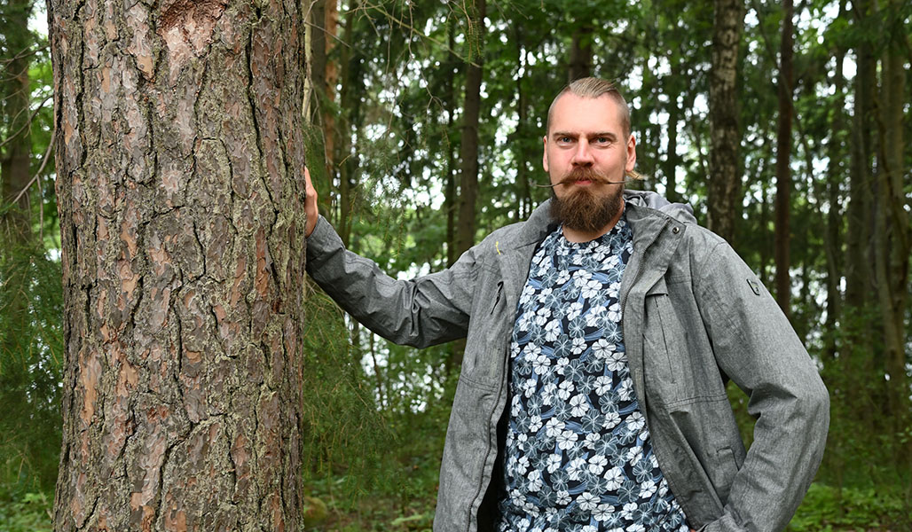 Tuomas Vakkila står intill en stor tall.