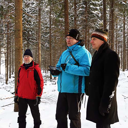 Auvo Alanne, virkesköpare Timo Poutiainen från Stora Enso och Markku Remes från Skogscentralen tittar på resultatet av en höggallring i en vintrig skog.